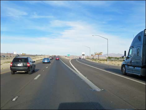 The interstate climbs steeply onto Mormon Mesa, a long stretch of flat country with the Mormon Mountains towering to the left and the high mountains of Gold Butte off to the right.